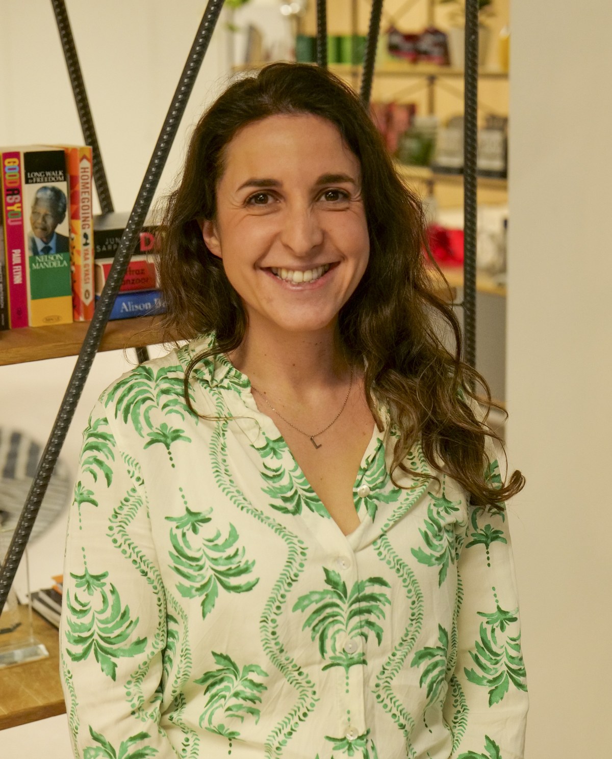 Amanda, smiling, standing in front of a bookshelf