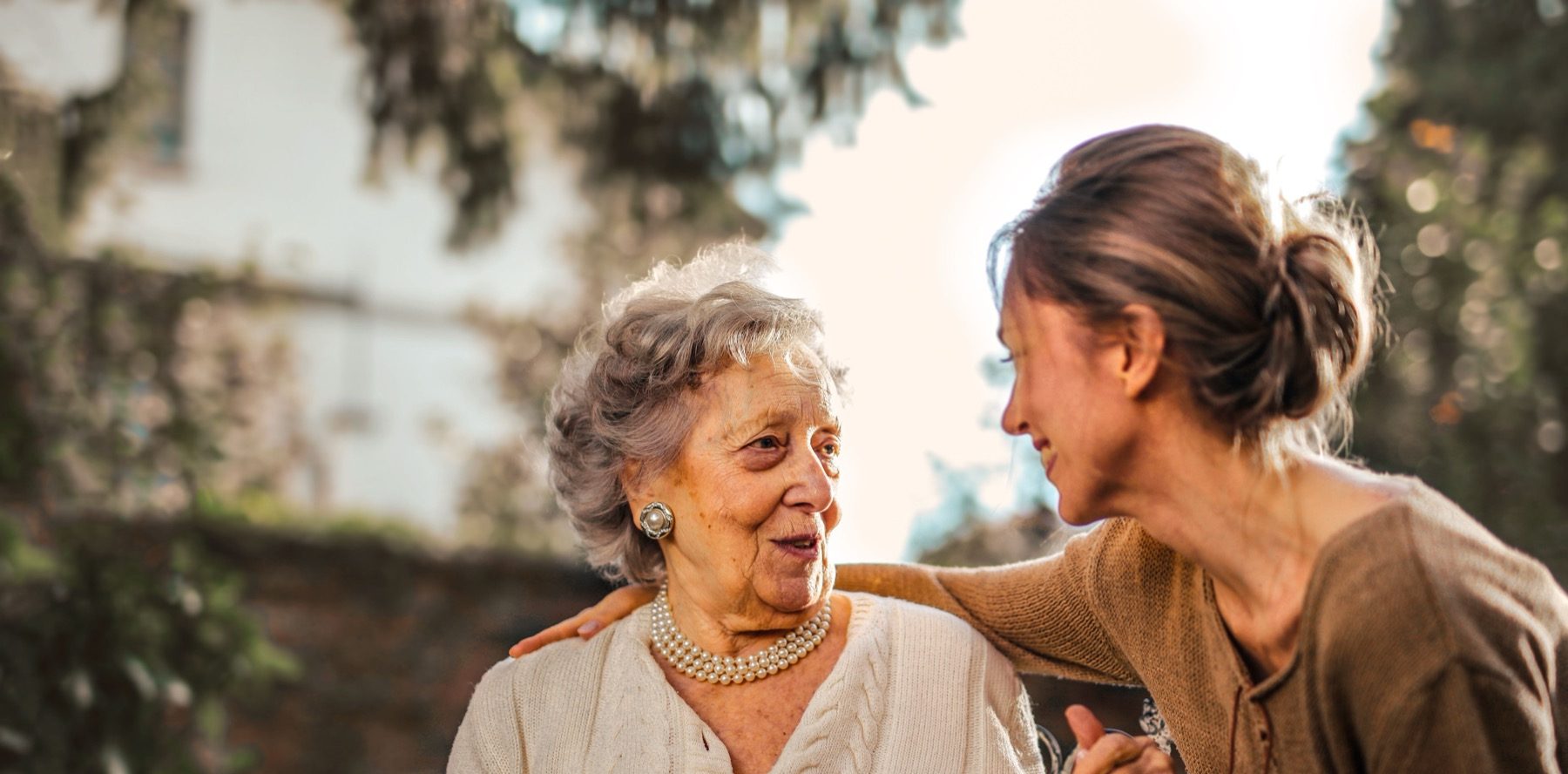 An older woman talking with a middle-aged woman outdoors