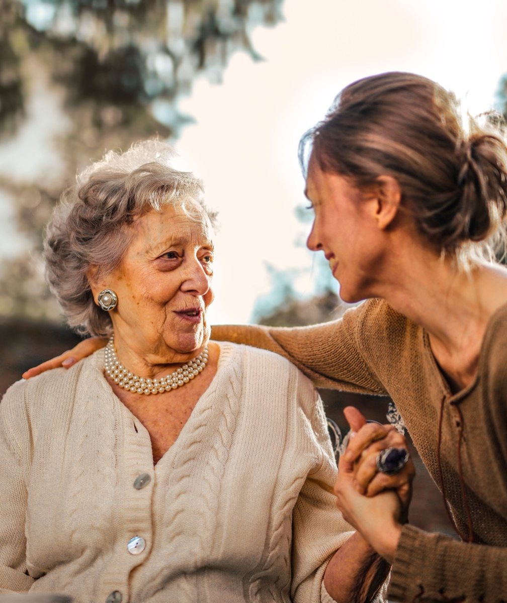 An older woman mid-conversation with a middle-aged woman